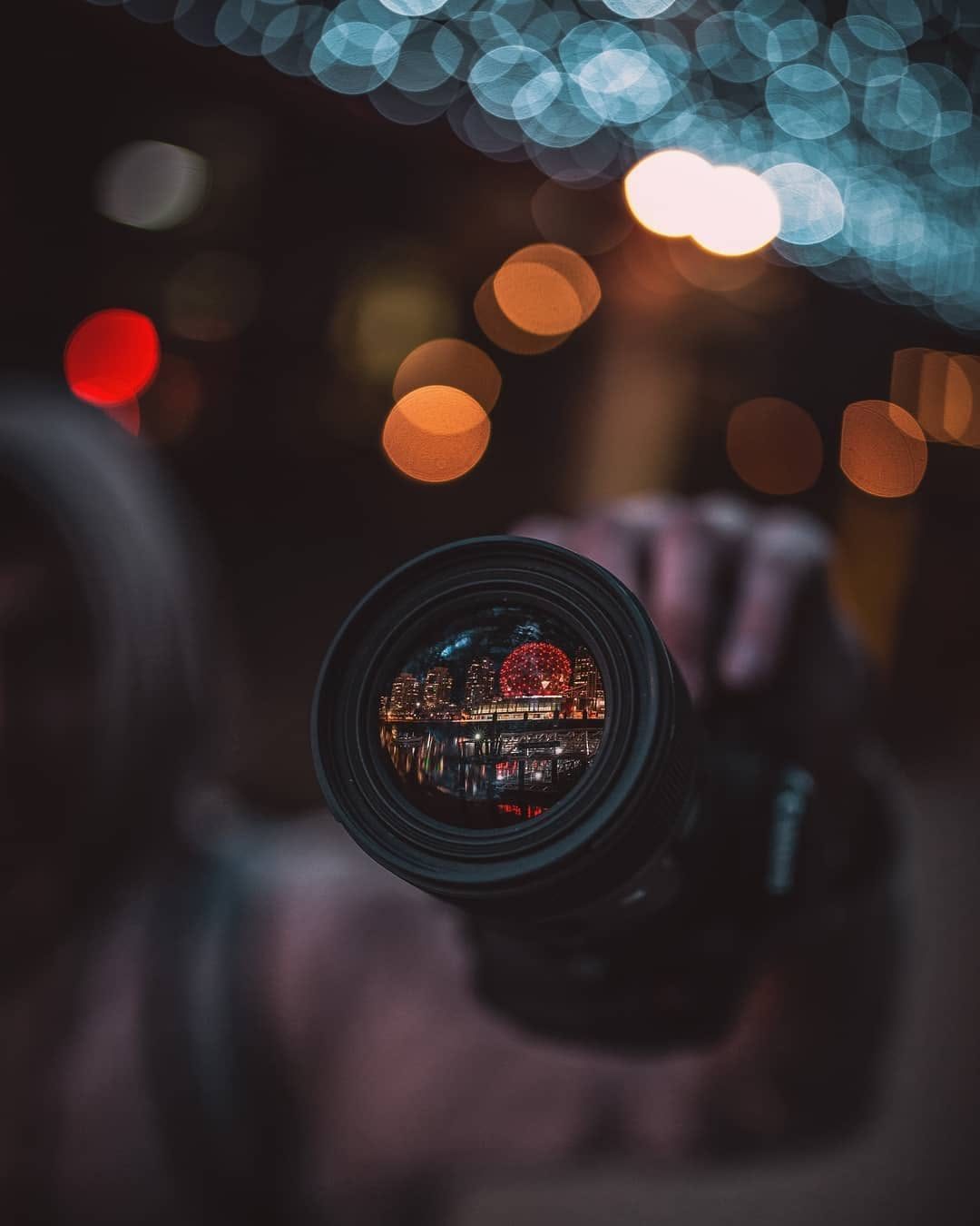 Camera lens reflecting Vancouver's Science World lit up at night